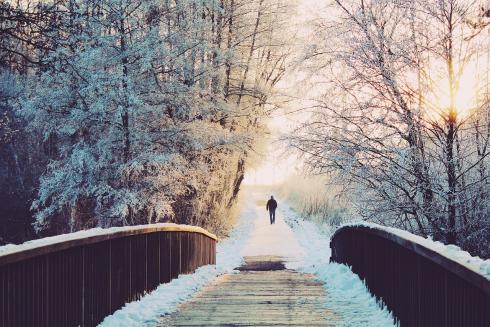 En man promenerar i vackert snölandskap.