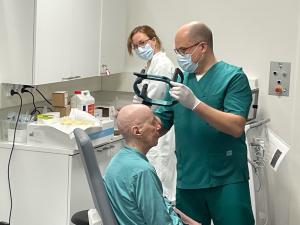 En läkare lägger en ställning på en patients huvud för ett neurologiskt ingrepp.