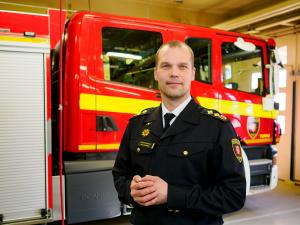 Vesa Halonen seisoo Varsinais-Suomen pelastuslaitoksen paloauton edessä.