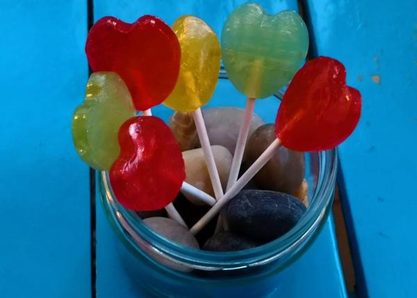 Different colored lollipops in a glass jar.