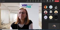 Nainen silmälasit päässään katsoo teams-kokouksessa kameraan. Taustakuvassa Varha-logo.