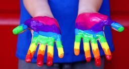 Sateenkaarivärein maalatut kädet